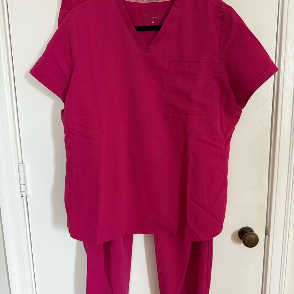Fabletics Women's Scrub Top and Jogger Pants Set in Bright Fuchsia.